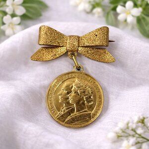 Vintage Gold-Tone Bow Brooch With Queen Elizabeth II & Prince Philip Coin Pendan